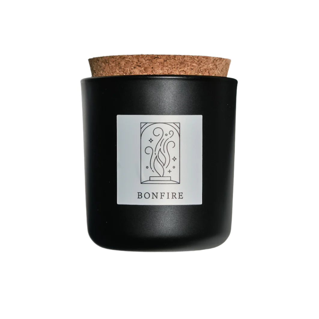 Bonfire candle in black apothecary glass with cork top for wholesale through Faire, Bulletin, Shoppe Object, and directly.