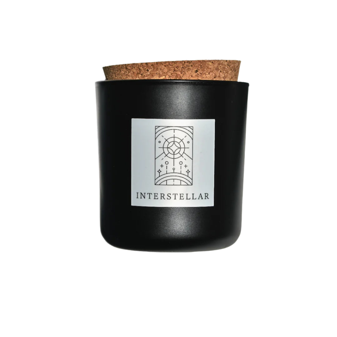 Interstellar candle in black apothecary glass with cork top for wholesale through Faire, Bulletin, Shoppe Object, and directly.